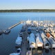 Colorful pier dock. Sailboats, boats, ships, on sunny day. Blue water, distant green trees, calm day - VideoHive Item for Sale