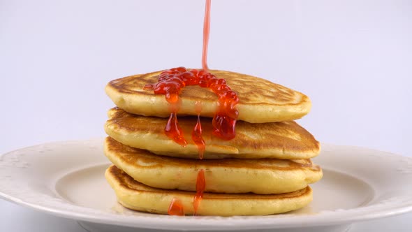 Pancakes with strawberry topping on a white background.