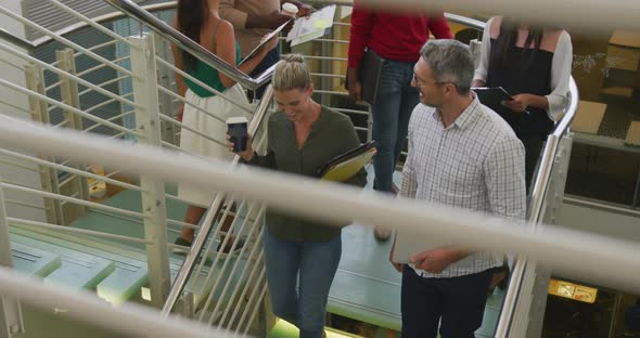 Diverse male and female business colleagues talking and walking