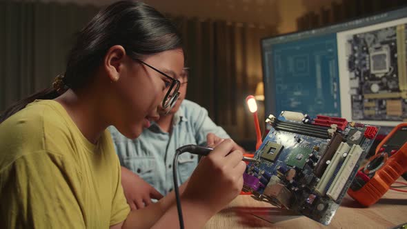 It Boy And Girl Are Soldering Electronic Circuit And Works With Computer, Genius Children Concept