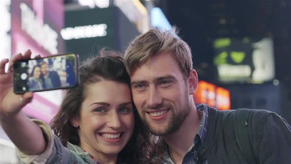 Couple taking selfie in Times Square, New York City, New York