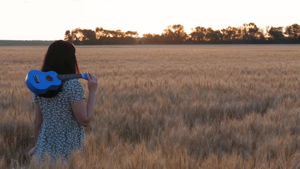 The Silhouette of a Happy Woman in a Wheat Field