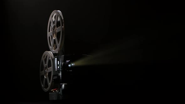 Dark Studio. Projector Illuminated By Lights Broadcasts a Movies