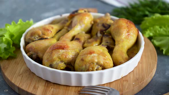 chef sprinkles the fried chicken drumsticks with chopped herbs