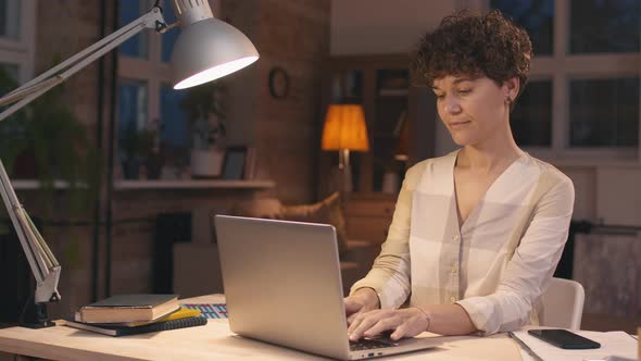 Woman Working on Laptop and Smiling for Camera