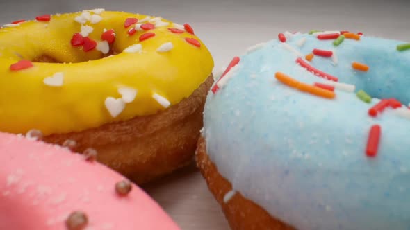 Delicious Multi-colored Donuts on a White Background. Smooth Dolly Motion