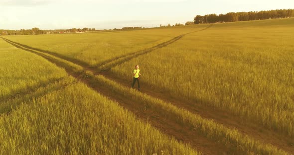 Sporty Child Runs Through a Green Wheat Field