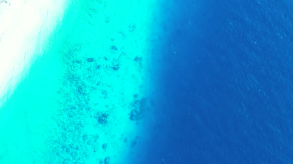 Aerial top down sky of tranquil island beach adventure by shallow lagoon with white sand background 