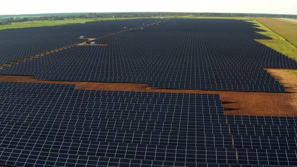 Top view of the power plant with solar panels. Beautiful green fields.