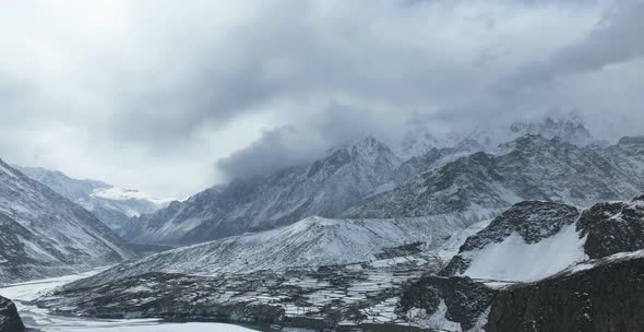 Aerial Timelapse Of Clouds Over Snow Covered Mountain Peaks Above Hussaini Village In Hunza Valley