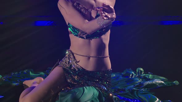 Fabulous Oriental Dancer Lying on the Surface of the Water in a Dark Studio