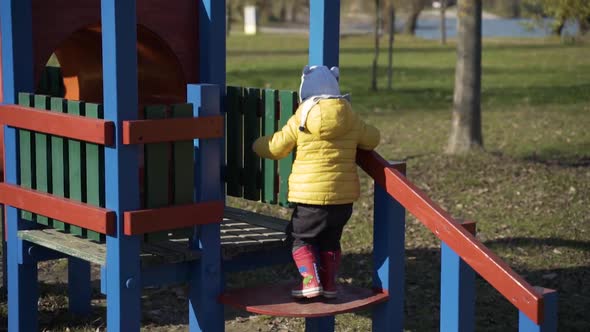 Adorable infant boy at playhouses in public playground, Zagreb, Croatia.