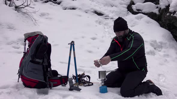 Hiker Cooking Breakfast At A Winter Campsite