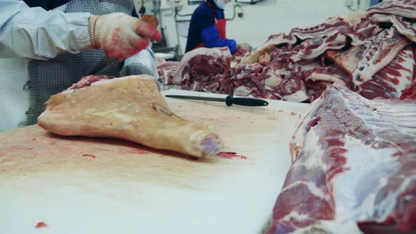 People Work with Meat at a Factory