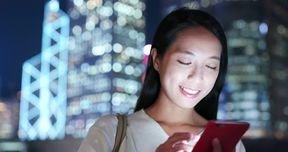 Woman use of mobile phone in city at night