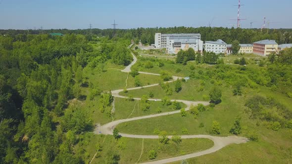 Hairpin Curves on Green Hill at Houses on Sunny Day Aerial