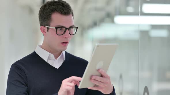 Young Businessman Reacting to Loss on Tablet