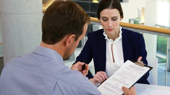 Executive taking sign of colleague on document 4k