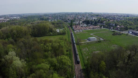 A train is riding across the residential district. 