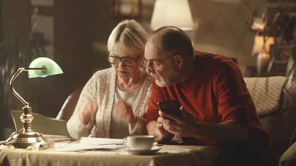 Aged Couple Checking Utility Bills in Evening