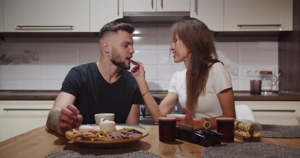 Girl And Boy Have Fun At The Table At Home In The Kitchen