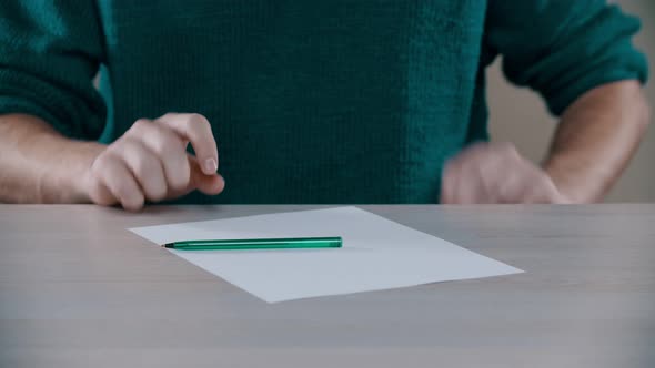 A Man Is Taking Out a Paper and a Pen