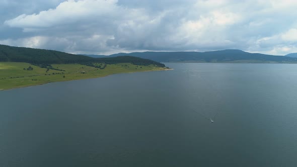 Aerial View of Big Lake with Clear Waters and Hills Surrounding It in Batak, Bulgaria