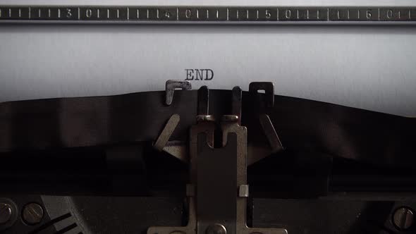 Typing word End on retro typewriter. Close up.