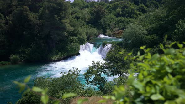 A torrent of  turquoise water turns white as it crashes through cascading rapids