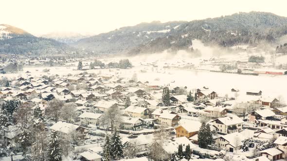 Snowy town of Garmisch-Partenkirchen below mountains, drone shot.