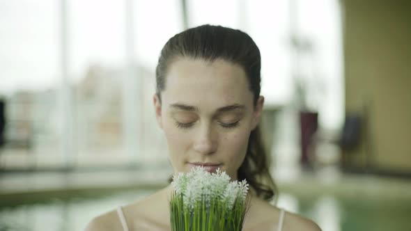 Young woman smelling fresh flowers