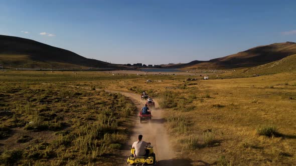 Aerial View From Behind ATVs by Lake and Mountain