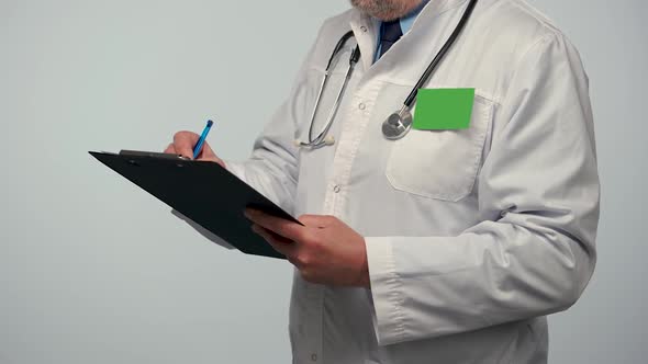 Male Doctor Takes Notes on a Medical History or Records His Research in a Black Folder