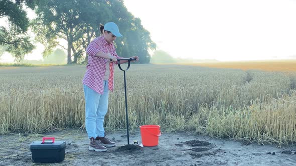 Female Agronomy Specialist Performing Soil Sampling at Sunrise