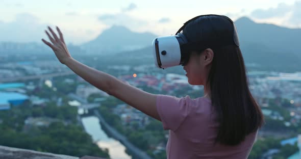 Woman watching on VR device in the evening 