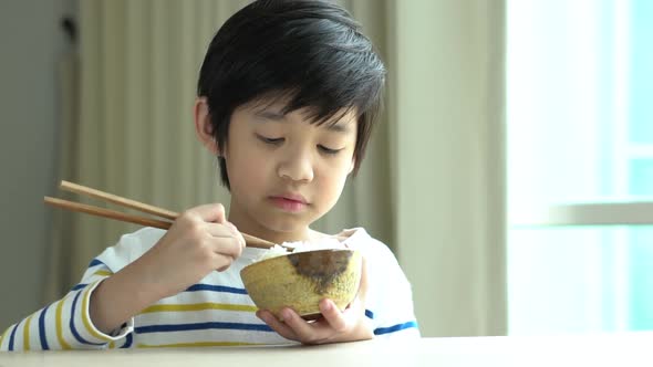 Cute Asian Boy Eating Rice With Chopsticks