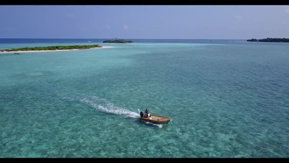 Aerial drone view landscape of luxury tourist beach vacation by blue green water with white sandy ba