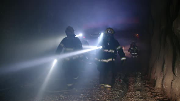 Rescue forces search for survivers inside a dark tunnel using flashlights