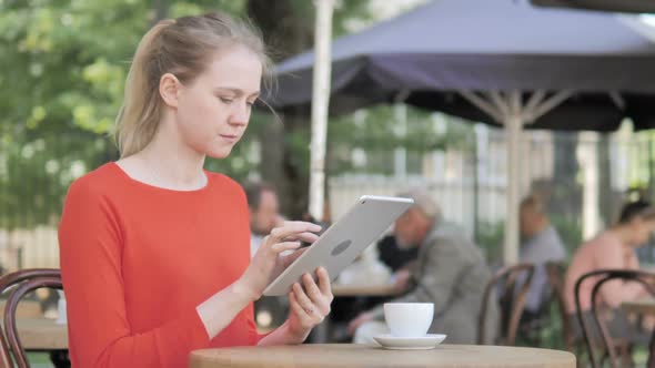 Young Woman Using Tablet Sitting in Cafe Terrace