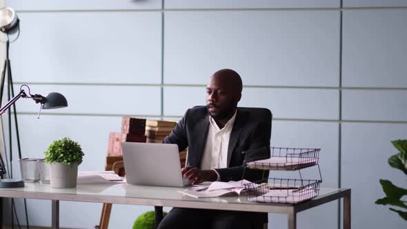 Photo of Handsome Employee Working in Office with Laptop in Front