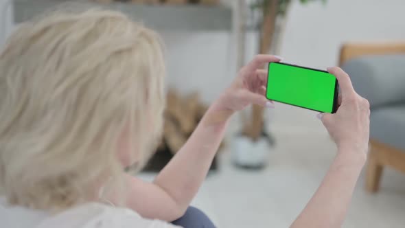 Rear View of Old Woman Using Smartphone with Chroma Key Screen on Yoga Mat