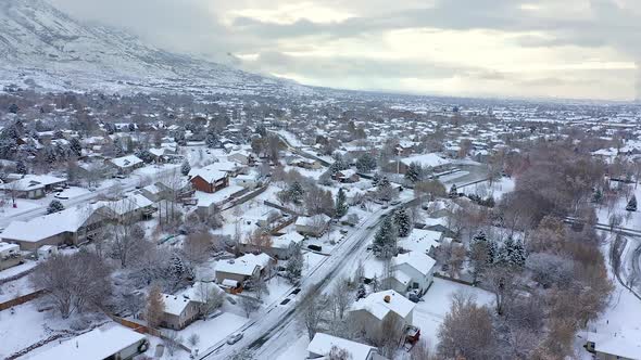 Aerial view flying over snow covered neighborhood in winter