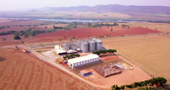 Grain storage silos and stunning scenery, high angle orbiting aerial view.