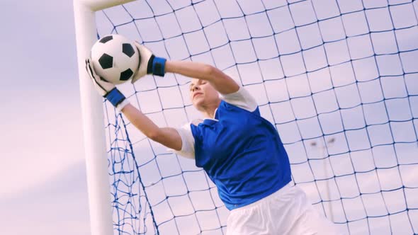 Goalkeeper in blue making a save