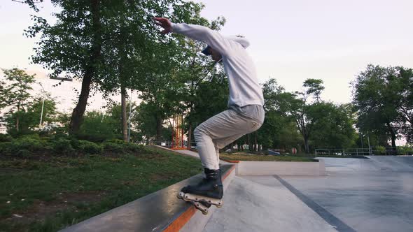 Aggressive Inline Roller Skater Doing Tricks in Concrete Skatepark Outdoors Slow Motion