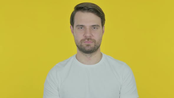 Happy Young Man Winking Eye on Yellow Background