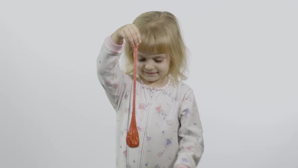 Kid Playing with Hand Made Toy Slime. Child Having Fun Making Red Slime