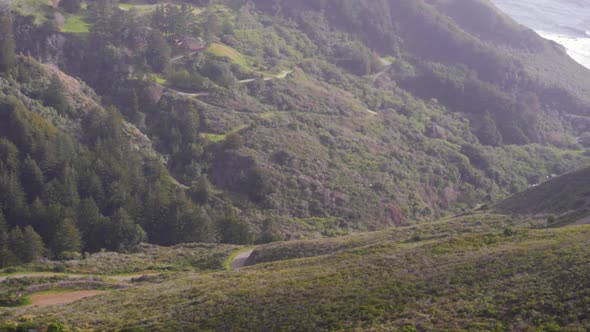 Ultra slow motion panning shot of winding road leading to ocean