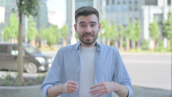 Outdoor Portrait of Young Man Celebrating Success