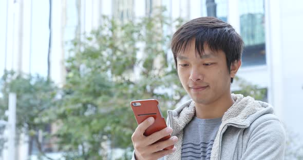 Asian Man Use of Mobile Phone in City